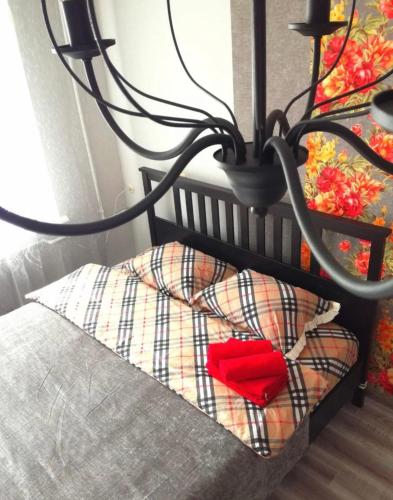 a bed with a red pillow and a lamp at VIP apart 401 in Tbilisi City