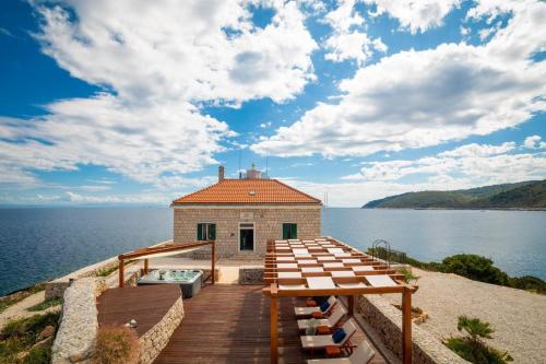 a house on the shore of a body of water at Luxury seafront Villa Lighthouse Ligero on Host island - Vis island in Vis