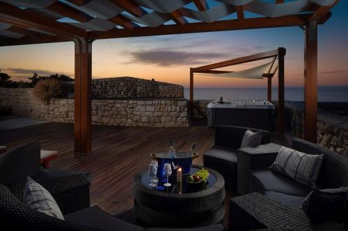a patio with chairs and a table with a view of the ocean at Luxury seafront Villa Lighthouse Ligero on Host island - Vis island in Vis