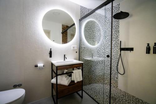 a bathroom with a shower and a sink and a mirror at Guesthouse diWINE in Merano