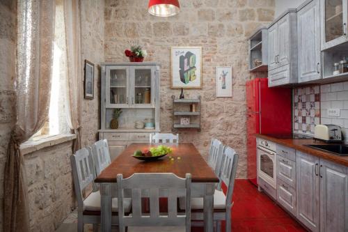 a kitchen with a table and chairs and a red refrigerator at Luxury seafront Villa Lighthouse Ligero on Host island - Vis island in Vis