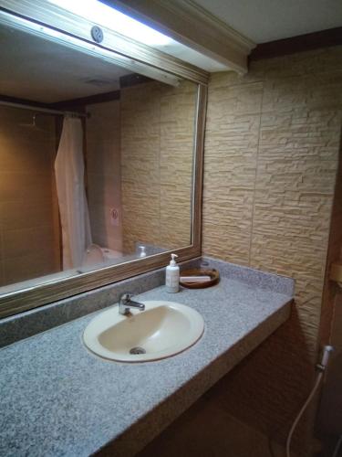 a bathroom counter with a sink and a mirror at Hotel Puri Dibia Kuta in Kuta
