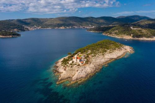 an island in the water with a house on it at Luxury seafront Villa Lighthouse Ligero on Host island - Vis island in Vis