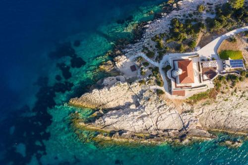 an aerial view of a house on a cliff near the water at Luxury seafront Villa Lighthouse Ligero on Host island - Vis island in Vis