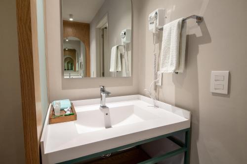 a bathroom with a white sink and a mirror at Oliva plaza hotel in Guadalajara