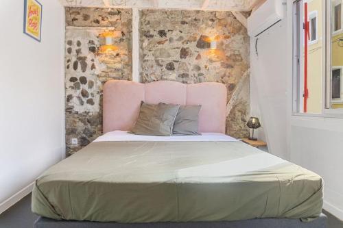 a bedroom with a large bed with a pink headboard at Maison Bernabet - Rooftop avec vue sur la Montagne Pelée in Saint-Pierre