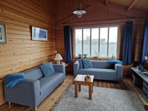 a living room with two couches and a large window at Boothuis Lauwersoog in Lauwersoog