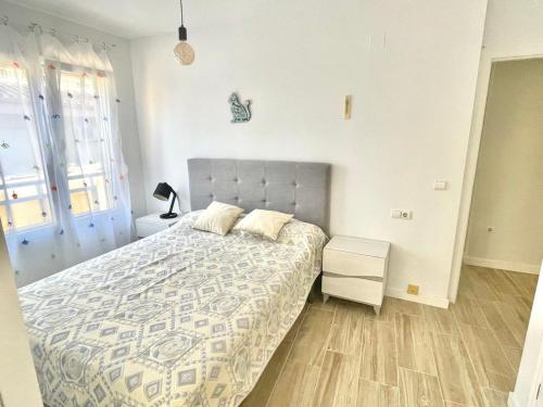 ein Schlafzimmer mit einem Bett mit einer grauen Tagesdecke in der Unterkunft Sea&Relax Apartment in Calpe