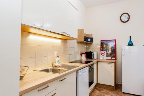 a kitchen with a sink and a refrigerator at Eco-Stúdió in Mosonmagyaróvár