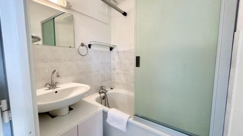 une salle de bain blanche avec un lavabo et un miroir dans l'établissement L'Estran 43, au Crotoy