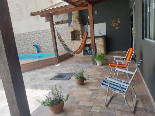 patio ze zjeżdżalnią i krzesłami oraz basenem w obiekcie Casa de praia em Unamar com piscina w mieście Cabo Frio