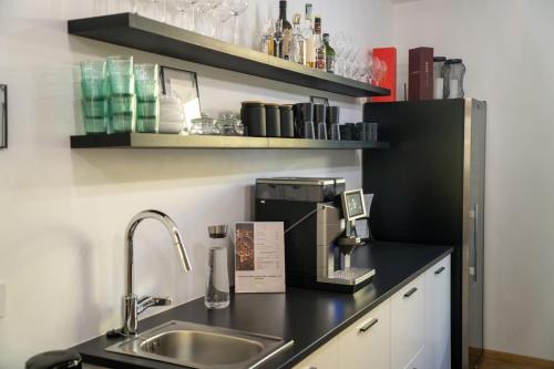 a kitchen counter with a sink and a coffee maker at Guesthouse diWINE in Merano