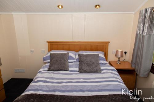 a bed with blue and white striped sheets and pillows at Rutland in Richmond