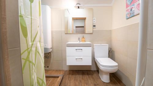 a bathroom with a white toilet and a sink at Palmy Home Dunakeszi in Dunakeszi