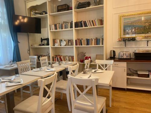 a dining room with white tables and white chairs at Villa Campana in Siófok