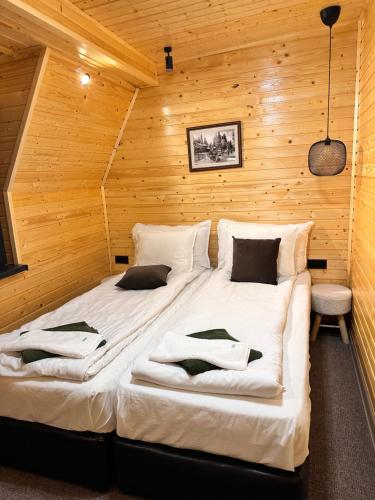 a bedroom with two beds in a wooden room at Boro Green Holiday Village in Borovets