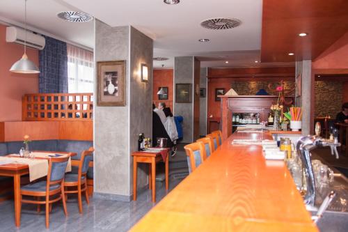 a restaurant with a long table and chairs and a fireplace at Hotel Rottal in Otrokovice