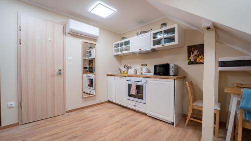 eine Küche mit weißen Schränken und einer Arbeitsplatte in der Unterkunft Palmy Home Dunakeszi in Dunakeszi