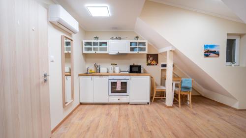 a kitchen with white cabinets and a staircase at Palmy Home Dunakeszi in Dunakeszi