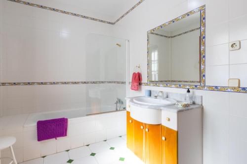 La salle de bains est pourvue d'un lavabo, d'une baignoire et d'un miroir. dans l'établissement Casa Lucia, à Periana