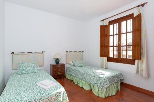 - une chambre avec 2 lits et une fenêtre dans l'établissement Casa Lucia, à Periana