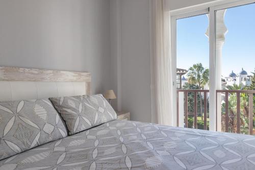 een slaapkamer met een bed en een groot raam bij El Zoco de Iñaki - Adults Only in Sitio de Calahonda