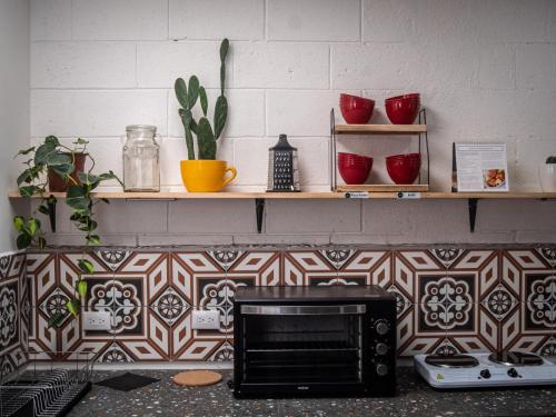 a microwave sitting on top of a kitchen counter at Lolas Hostal, Habitacion Exclusiva para Mujeres, 2 camarotes, precio por cama in San José