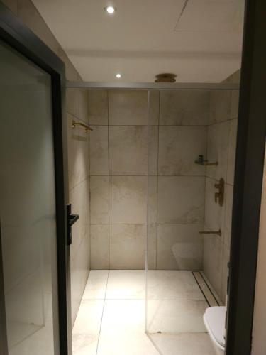 W łazience znajduje się prysznic ze szklanymi drzwiami. w obiekcie My Kingdom Munnar w mieście Munnar
