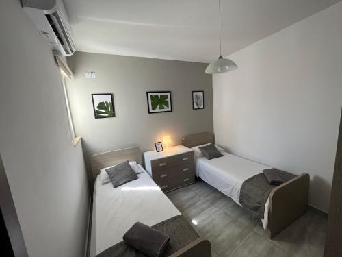 a bedroom with two beds and a desk with a lamp at F6 Room 2, Private Room two single beds shared bathroom in shared Flat in Msida