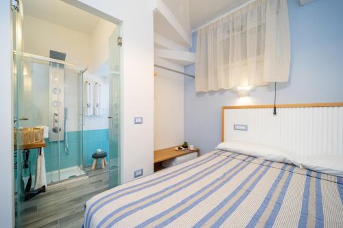 1 dormitorio con cama y ducha en Grenilù Sea, en Crotone