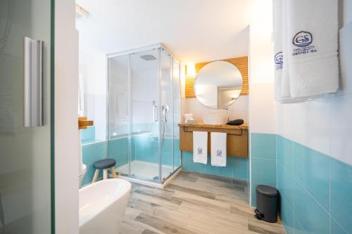 a bathroom with a glass shower and a sink at Grenilù Sea in Crotone