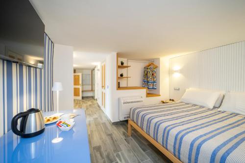 Un dormitorio con una cama grande y una mesa azul en Grenilù Sea, en Crotone
