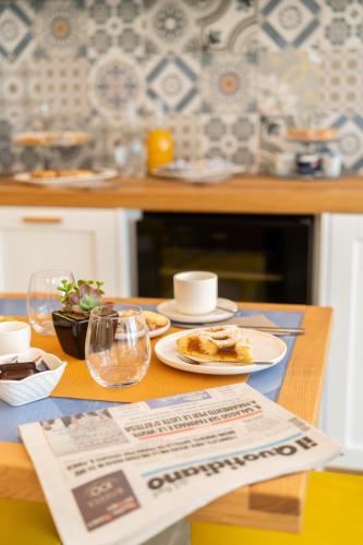 a table with plates of food and a newspaper at Grenilù Sea in Crotone