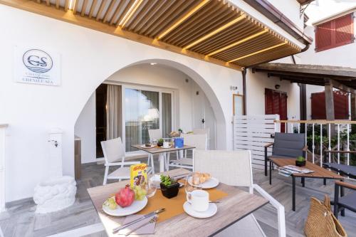 a patio with tables and chairs and a building at Grenilù Sea in Crotone