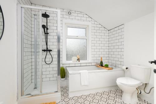 a white bathroom with a tub and a toilet at Asher Suite by Koya Homes in Barry