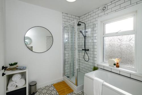 a white bathroom with a tub and a window at Asher Suite by Koya Homes - 2-Bedroom Home, Downtown Barry, Free Parking in Barry