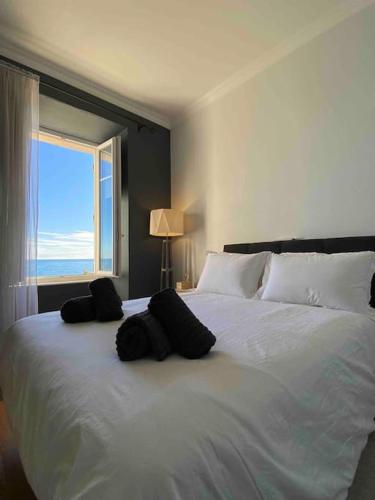 une chambre avec un grand lit blanc avec une fenêtre dans l'établissement Stunning view, à Antibes