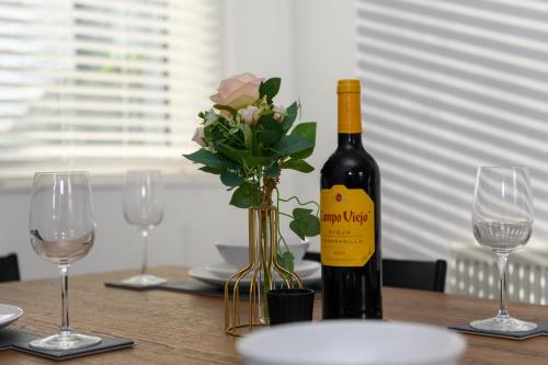 a bottle of wine sitting on a table with glasses at Asher Suite by Koya Homes - 2-Bedroom Home, Downtown Barry, Free Parking in Barry