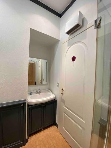 La salle de bains est pourvue d'un lavabo et d'une porte blanche. dans l'établissement Stunning view, à Antibes