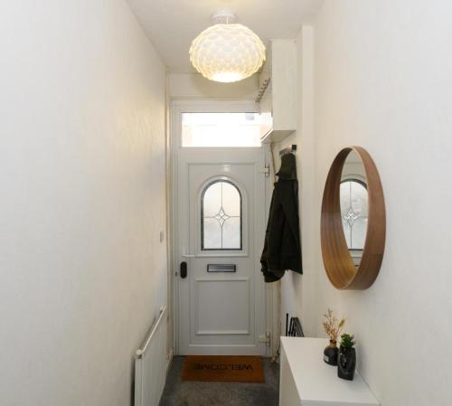 a hallway with a white door and a mirror at Asher Suite by Koya Homes - 2-Bedroom Home, Downtown Barry, Free Parking in Barry