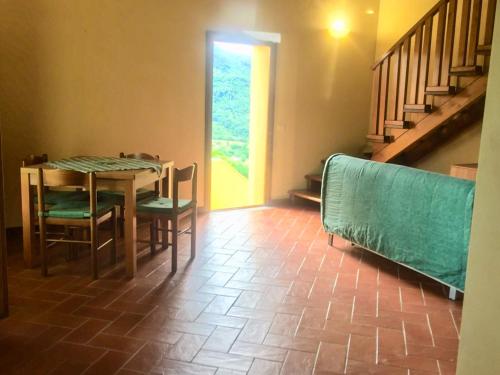 comedor con mesa, sillas y escaleras en Il Borrino en Gavinana
