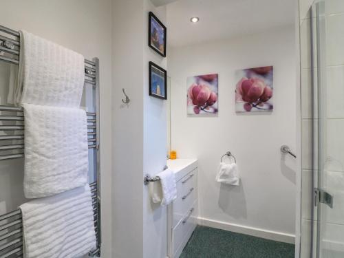 a white bathroom with a shower and a sink at Maples Annex in Heanor