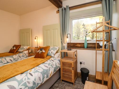 霍姆弗斯的住宿－Wells Cottage，一间卧室设有两张床和窗户。