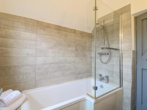 a bathroom with a shower and a bath tub at 7 The Village in Ilkeston