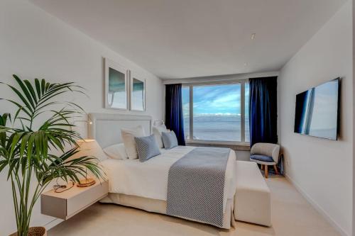 a bedroom with a bed and a large window at Luxury triplex + pool, jacuzzi - SissiPark Azul in Acantilado de los Gigantes