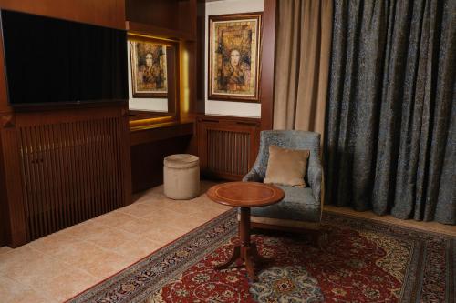 a living room with a chair and a table at Le Cedrus Hotel in Al Arz