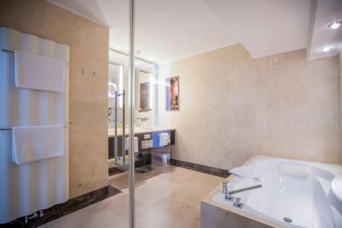 La salle de bains est pourvue d'un lavabo et d'une douche. dans l'établissement Iris Porsche Hotel & Restaurant, à Mondsee