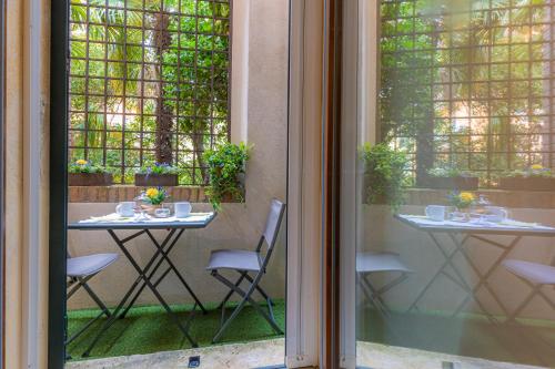 a balcony with a table and chairs and a window at Orti Manara Design Apartments in Verona