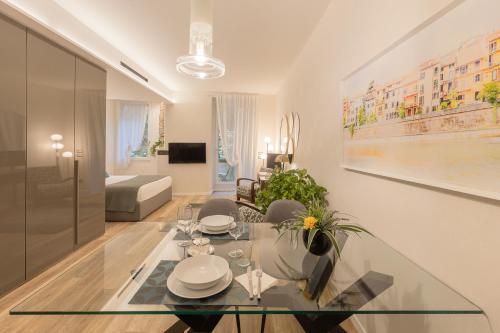 uma sala de estar com uma mesa de vidro e cadeiras em Orti Manara Design Apartments em Verona