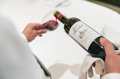 a person is holding a bottle of wine at De Lindenhoeve Boutique Hotel in Sluis